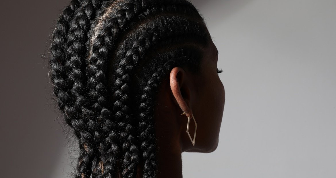 mulher negra com cabelo castanho escuro e penteado trança nagô